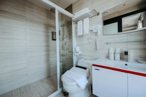 金宁乡闲事别馆的一间带卫生间和玻璃淋浴间的浴室