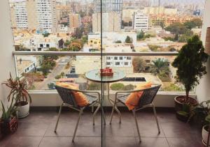 利马Exclusivo Departamento 2BR en San Isidro的配有大窗户的客房内的桌椅