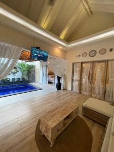 金巴兰Villa deluna的客厅设有桌子和游泳池