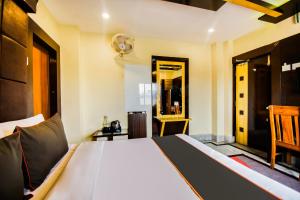 ĀsansolMeera International的一间卧室配有一张大床和镜子