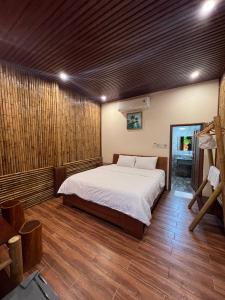 岘港Homestay Da Nang Full House的一间卧室配有一张床,铺有木地板