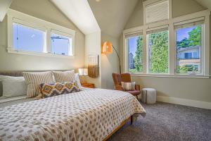 西雅图Exquisite Central Townhome with Spacious Loft and Gourmet Kitchen的一间卧室配有一张床、一把椅子和窗户。