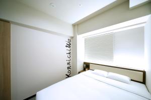 京都Travelodge Kyoto Shijo Kawaramachi的白色的卧室设有床和窗户