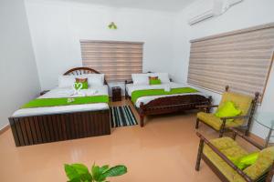 KāladiParudeesa - Kerala的一间卧室配有两张床、一张沙发和一把椅子