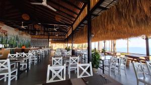 磅士卑省Romdoul Kirirom Resort的一间设有白色桌椅的餐厅和一间酒吧