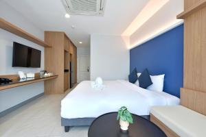 曼谷VST Punnawithi - SHA Certified的酒店客房设有两张床和一张桌子。