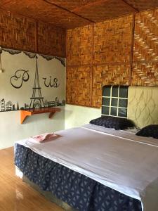 武吉拉旺Asim Paris Guesthouse的一间带一张大床的卧室,位于带木墙的房间