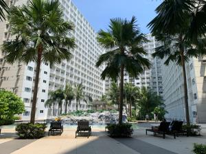马尼拉SMDC Shore Residences 1 Mall of Asia Complex Pasay的一座棕榈树环绕的大建筑