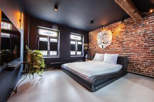 鲁尔蒙德Chambers Roermond的一间卧室设有一张床和砖墙