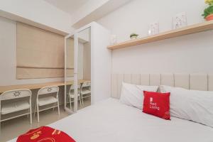 贝克西RedLiving Apartemen Transpark Juanda - Frams Properti Tower Jade with Netflix的一间卧室配有一张红色枕头的床