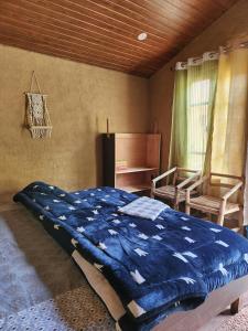 比尔瓦Monkey Mud House and Camps, Bir的卧室配有蓝色被子
