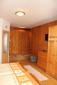 斯米扎尼玛丽亚小旅馆的一间卧室设有木墙、一张床和电视。
