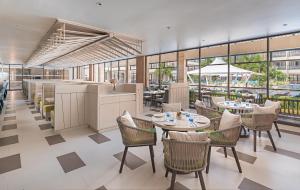 长滩岛Henann Park Resort的餐厅设有桌椅和窗户。