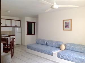 喀巴里特拉蓬塔公寓式酒店的一间带蓝色沙发的客厅和一间厨房