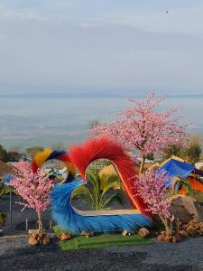 Ban Wang SaiThe Cloud View วิวเหนือเมฆแคมป์ ที่พักวิวสวยเขายายเที่ยง的鸟的雕塑,有五颜六色的羽毛和树木