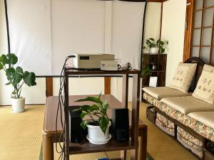 TakedaHatake no Oyado - Vacation STAY 13929v的客房设有两张床和一张带笔记本电脑的桌子。