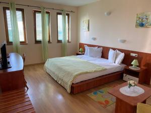 布尔加沃Guest House Golden Flake 4km from Bolata beach的一间带一张大床的卧室,位于带窗户的房间内