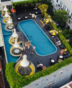 暹粒The Twizt - Lifestyle Hostel & Hotel的游泳池的顶部景色,周围的人坐在游泳池周围