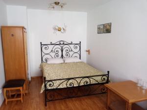 舒门Family Hotel Rai的卧室配有一张黑色床,位于带桌子的房间