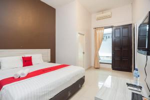 茂物RedDoorz Syariah near Taman Air Mancur Bogor的一间卧室配有一张床和一台平面电视