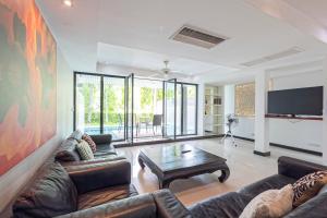 卡图The Fairways Villas - 4 bedroom for 10 guests - 7kms to Patong beach的客厅配有沙发和桌子