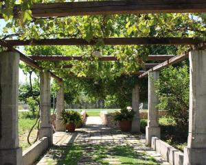 乌真托Villa CICIA的人行道上种有盆栽植物的木凉亭