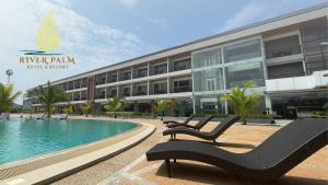 BugallonRiver Palm Hotel and Resort powered by Cocotel的一座带游泳池和大楼的度假村