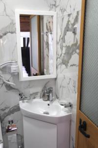 克鲁亚DEAL Castle View Rooms的白色的浴室设有水槽和镜子