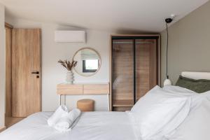 卡兰兹拉Five Senses Of Luxury的卧室配有白色的床和镜子