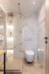 卡兰兹拉Five Senses Of Luxury的浴室设有白色卫生间和大理石墙壁。