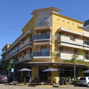 科隆普拉塞酒店的前面有雨伞的黄色建筑