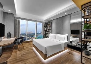 芝卡朗Nuanza Hotel & Convention Cikarang的卧室配有白色的床和带书桌的书桌