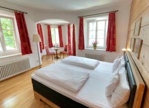 施利尔塞特洛法尔酒店的卧室配有一张带红色窗帘的大型白色床