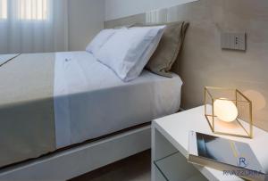 圣维托罗卡波Rivazzurra Beach Rooms的一间卧室配有一张床和一张带台灯的桌子