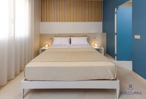 圣维托罗卡波Rivazzurra Beach Rooms的一间卧室配有一张大床,上面有两盏灯