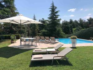 普拉奇里奥Villa Casa Chrissy的游泳池旁配有遮阳伞的桌椅