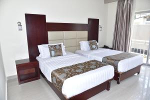 卢萨卡山谷异国情调酒店的酒店客房设有两张床和窗户。
