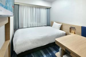 名古屋名古屋荣华盛顿广场酒店的小房间设有床和窗户