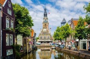 阿尔克马尔Het Popelhuisje的一座在河边设有钟楼