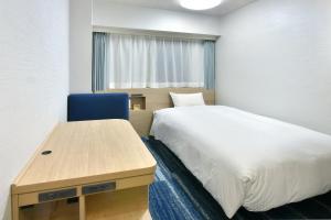 名古屋名古屋荣华盛顿广场酒店的一间小卧室,配有一张床和一张书桌