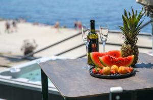 斯普利特Via Mare Luxury Rooms的一张桌子,上面放着一盘水果和一瓶葡萄酒