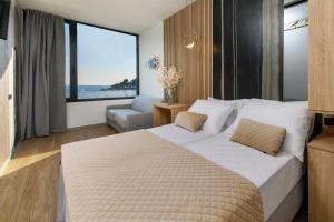 斯普利特Via Mare Luxury Rooms的一间卧室设有一张大床,享有海景