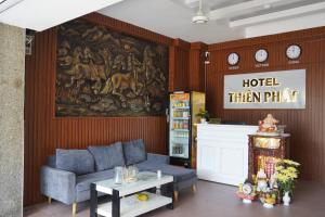 胡志明市Thiên Phát Hotel - SECC的客厅配有沙发和墙上的绘画