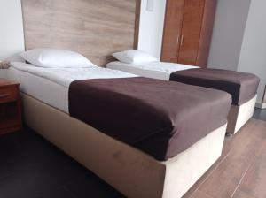 弗拉基米尔-沃伦斯基Volyn HOTEL LUDMIR的配有两张床垫的酒店客房内的两张床