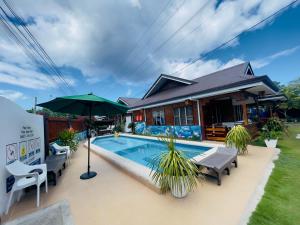 莫阿尔博阿Dolce Vita Resort的一座带游泳池和遮阳伞的房子