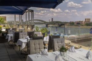 科隆玛丽蒂姆科隆酒店的一间带桌椅的河景餐厅