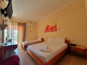 阿尔库季岛Brati II Beach Hotel的酒店客房设有两张床和电视。