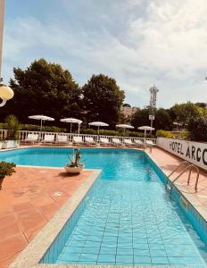 塞勒里古Hotel Arcobaleno的一个带椅子和遮阳伞的大型游泳池
