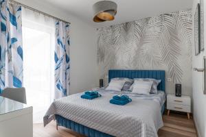 库多瓦-兹德鲁伊Apartamenty Pod Cisem Lux的一间卧室配有蓝色的床和2条毛巾