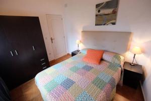 托罗埃利亚-德蒙特格里Moli 2的一间卧室配有一张带橙色枕头的床